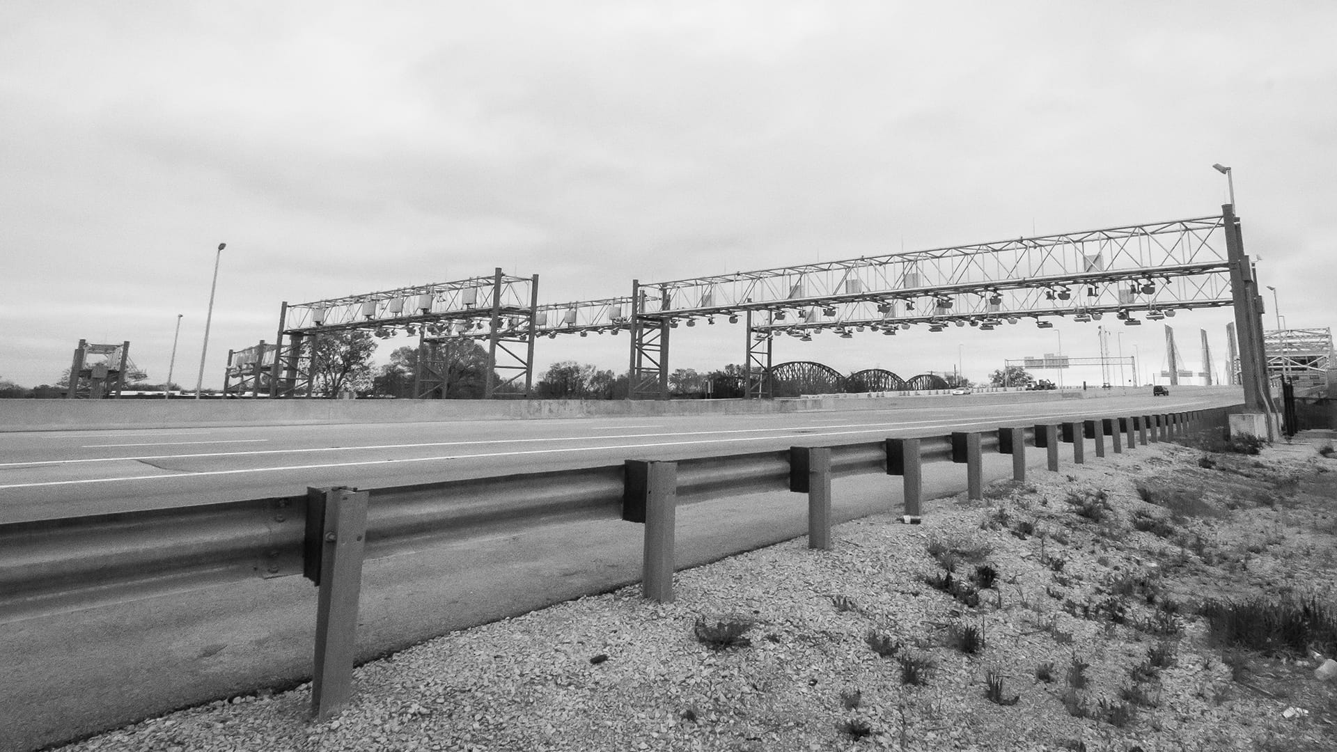 Highway guardrail along a roadway with ITS gantries visible in background — James H Drew and Tennessee Guardrail guardrail installation