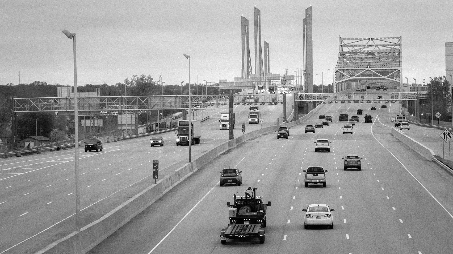 Multi-lane Indianapolis interstate highway with overhead gantry structures and bridge — James H Drew Corporation infrastructure project